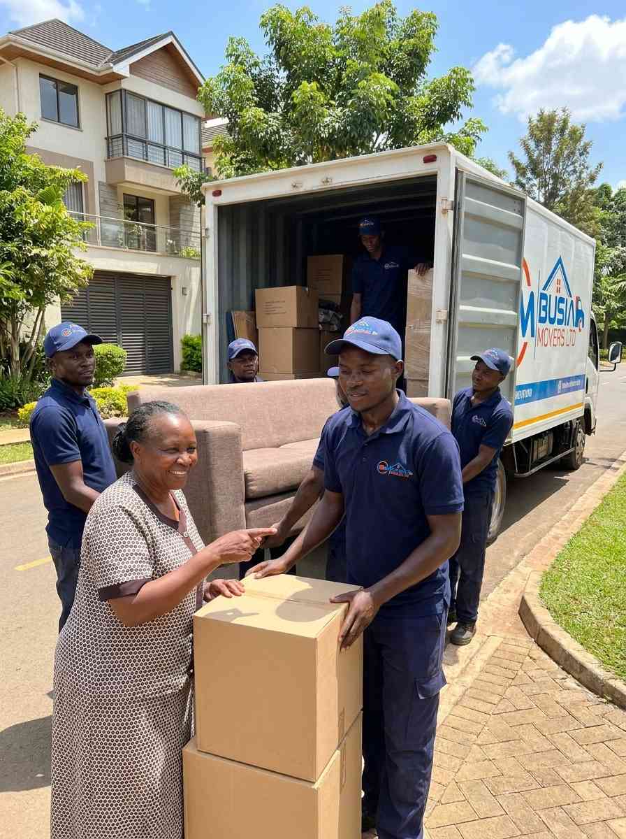 Busia Movers team handing boxes to client